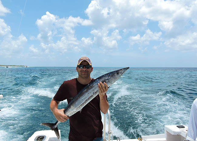 Hector happy with his catch in a Cozumel bottom fishing tour.